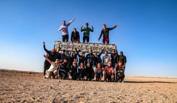 Group of people posing with a Tropic of Capricorn sign.