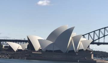 Famous opera house with a bridge in the background.
