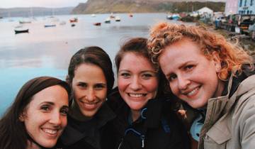 Four friends posing with a scenic water backdrop.
