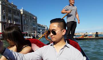 Man on a gondola ride in Venice with gondolier in the background.