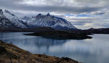 Panoramic view of a lake with surrounding mountains.