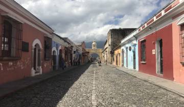 Colorful street in Antigua, Guatemala with cobblestone road and archway.