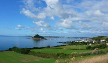 A scenic view of Saint Michael's Mount with the ocean and coastline.
