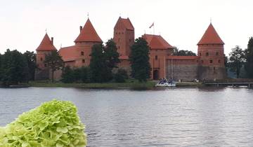 Trakai Castle surrounded by a lake with boats.