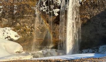 Large picturesque waterfall with a faint rainbow beneath.
