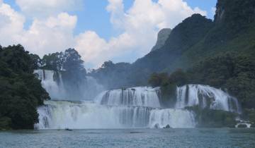 Stunning waterfalls surrounded by lush greenery under a bright blue sky.