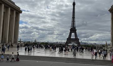 Eiffel Tower with people gathered around the plaza.