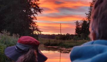People watching a beautiful sunset over a river.