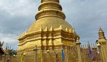 Golden pagoda with intricate design under cloudy skies.