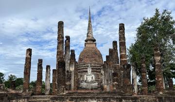 Ancient temple ruins with a spire surrounded by pillars.