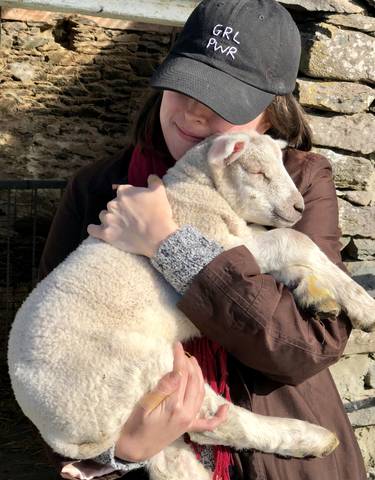 Person holding a sleeping lamb.