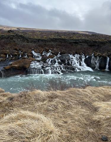 Picturesque waterfall flowing over layered rock formations.