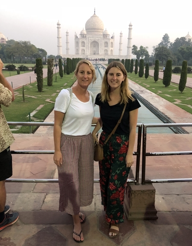 Two women standing in front of the Taj Mahal grounds.
