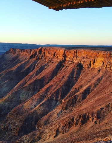 Stunning view of a canyon at sunset with rugged cliffs.