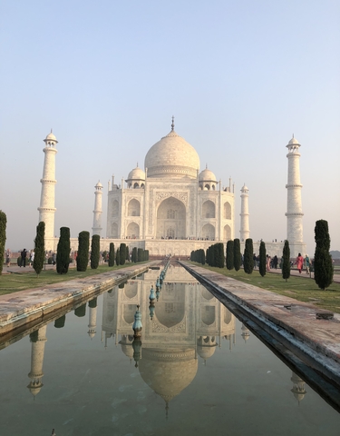 Iconic view of the Taj Mahal surrounded by gardens and water features.