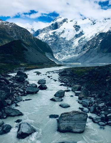 River flowing through a rocky valley with snowy peaks.