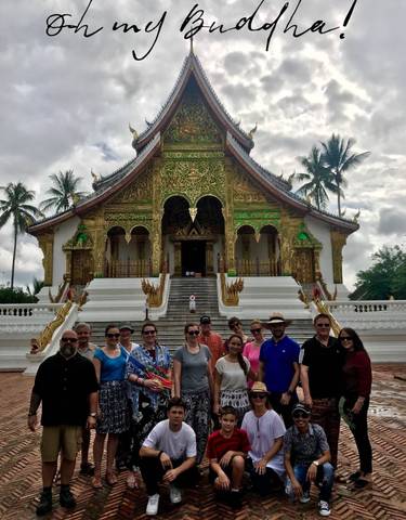 Group of people in front of a decorated temple.