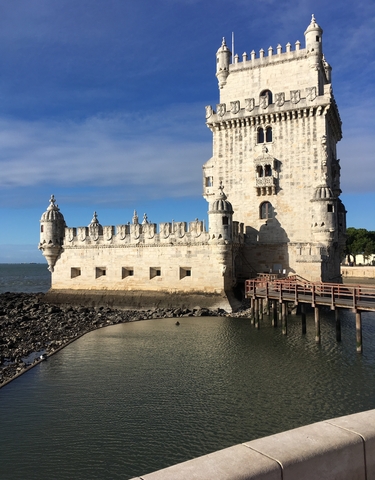 Stone fortification by the water with towers and detailed architecture.