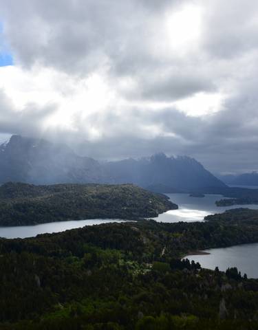 Scenic aerial view of lakes and mountains with dramatic clouds.
