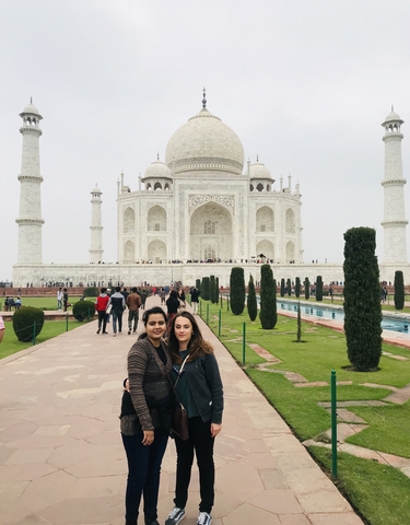 Tourists posing in front of the Taj Mahal.