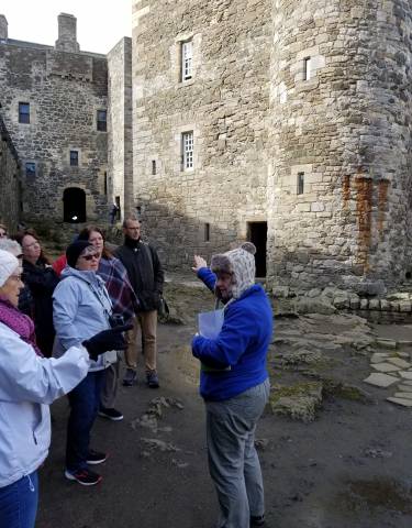 A tour group with a guide in a historic stone building
