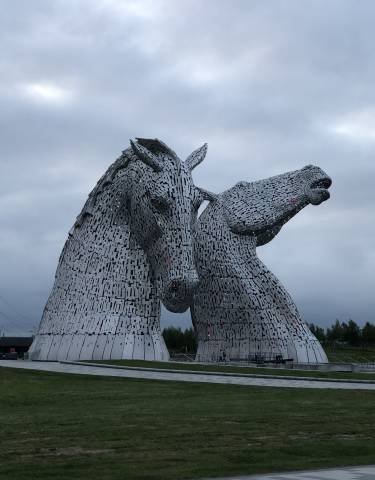 Two horsehead sculptures made of metallic pieces.