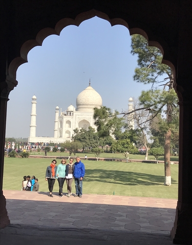 A group of tourists posing in front of the Taj Mahal.