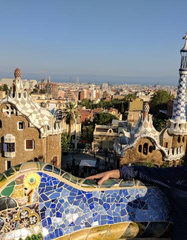 View of Park Güell with unique architectural features and a person enjoying the view.