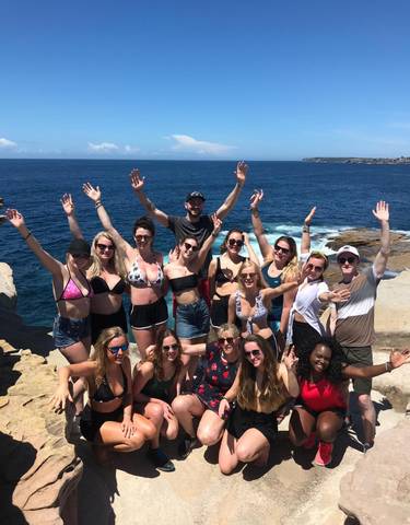 Group of people lounging on a sailboat with scenic views.