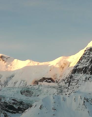 Sunlight hitting snowy mountain peaks