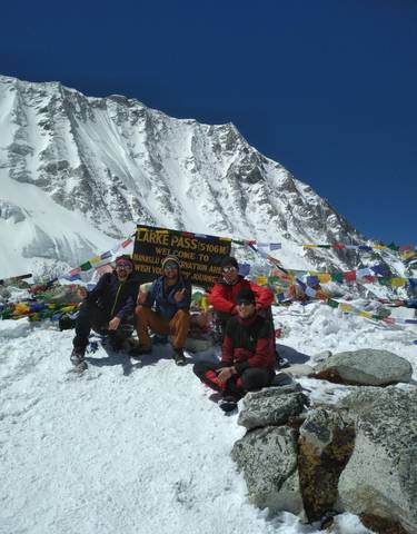 Group of people at Larke Pass, with mountains and snow in the background.