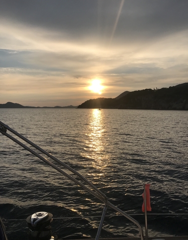 Sunset over the sea with hills in the background.