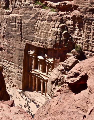 Petra archaeological site carved into pink sandstone cliffs.