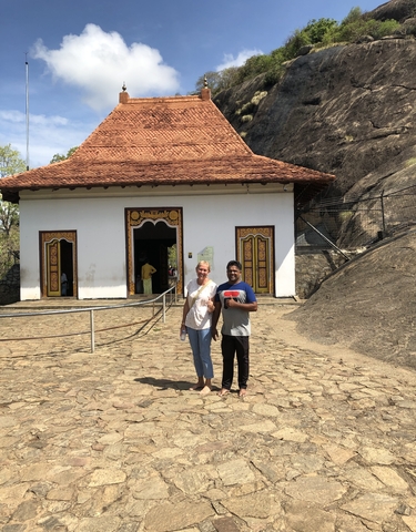 Two people standing in front of a traditional building.