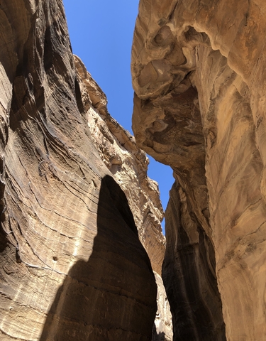Rock formations with a narrow opening under a blue sky