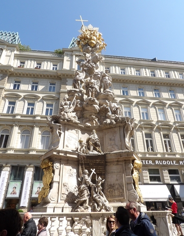 Close-up of an ornate statue in front of a classical building.