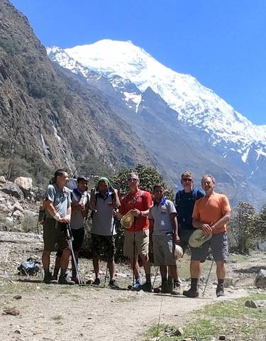 Group of hikers posing with mountain in the background.