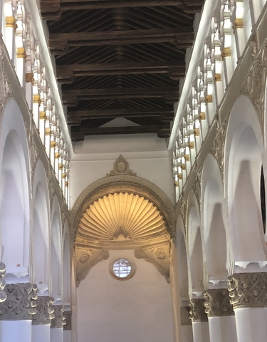 Interior of a historical building with ornate arches and ceiling.