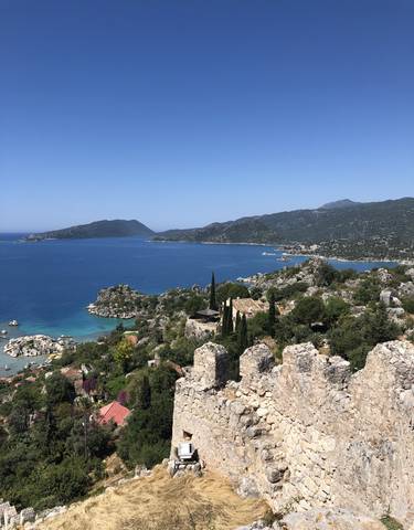 Scenic coastal view with turquoise waters and rocky hills.