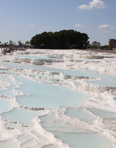 White travertine terraces filled with turquoise water.