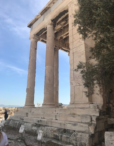 Columns of an ancient structure against a clear blue sky.