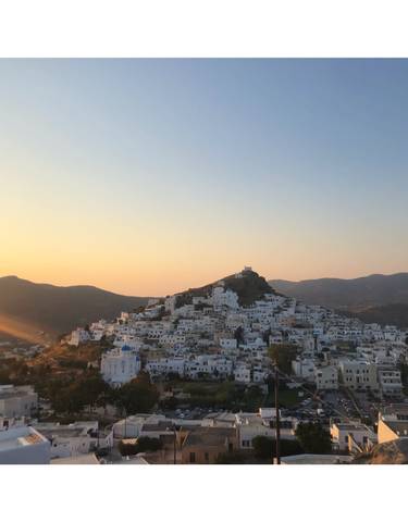 Sunset view of a hilltop town with white buildings.