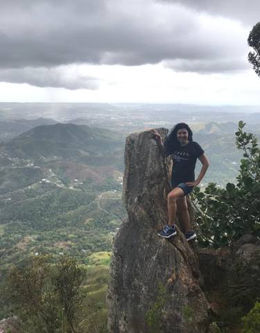 Woman posing on a rock with a mountain view.
