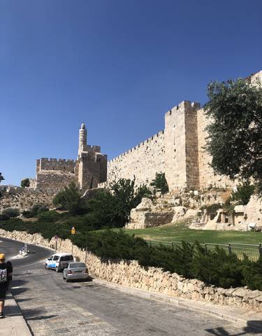 Historic stone walls and tower under a clear blue sky.