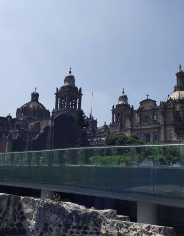 A grand cathedral with domed roofs against a blue sky.