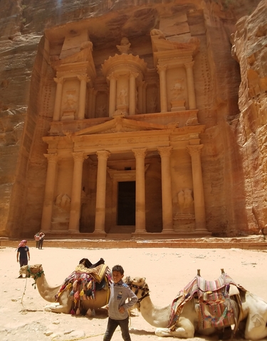 People exploring Petra's Treasury, a grand carved facade.
