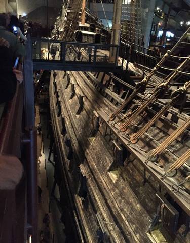 Inside a museum with wooden ship hull.