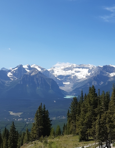 Mountain range with snow-capped peaks and a lake.