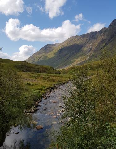 Mountain valley scene with a stream flowing through.