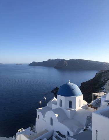 View of the sea with a white church dome in the foreground.